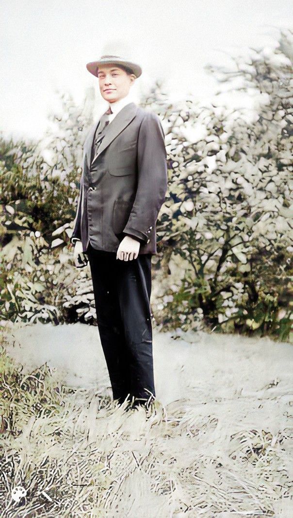Philip standing in a suit wearing a hat