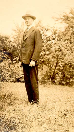 Philip standing in a suit wearing a hat